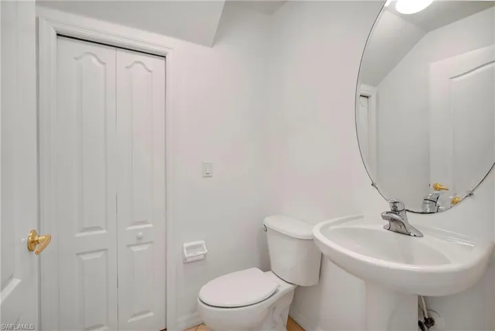 Downstairs powder room with storage under the stairs.