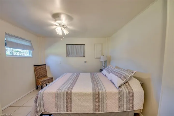 Tiled bedroom featuring ceiling fan