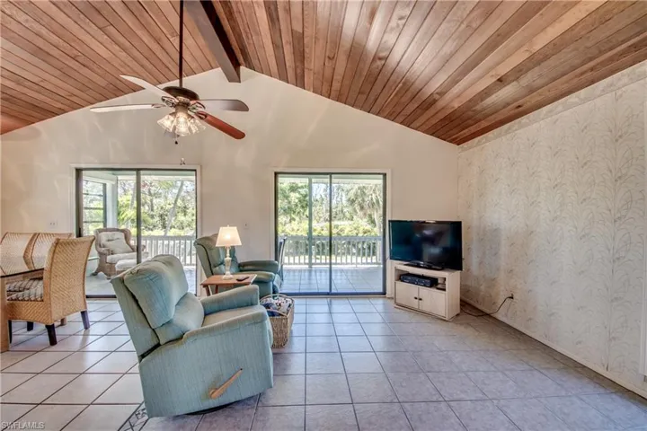 Unfurnished living room featuring ceiling fan, high vaulted ceiling, wood ceiling, and light tile patterned floors