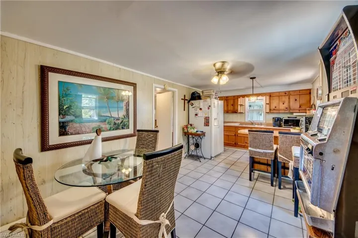Tiled dining room with ceiling fan and sink