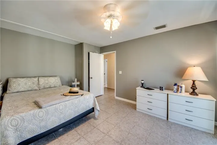 Bedroom with ceiling fan and light tile patterned floors