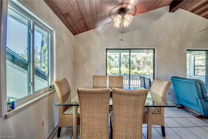 Dining room featuring ceiling fan, wood ceiling, plenty of natural light, light tile patterned floors, and lofted ceiling