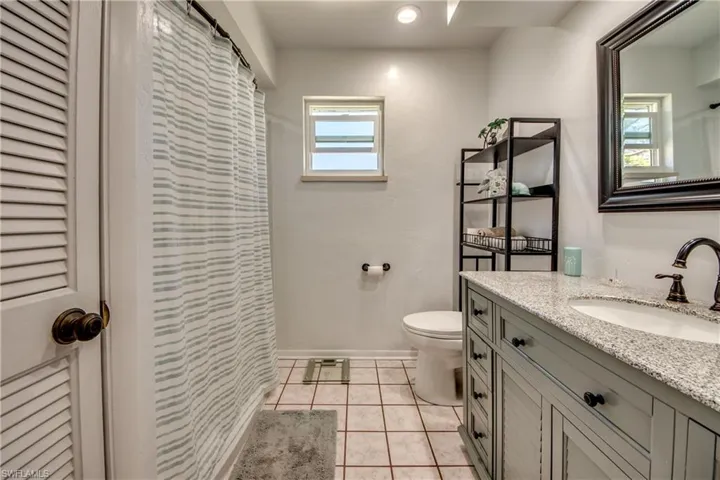 Bathroom featuring tile patterned flooring, vanity, and toilet