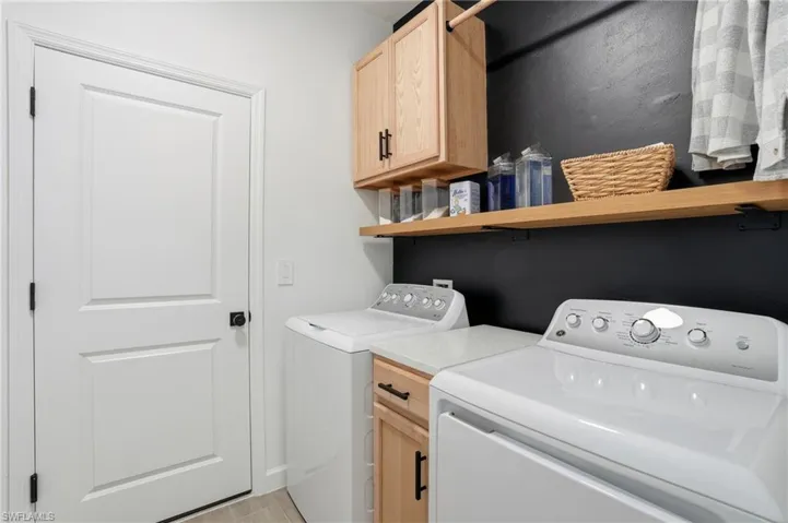 Laundry room with independent washer and dryer and cabinet space