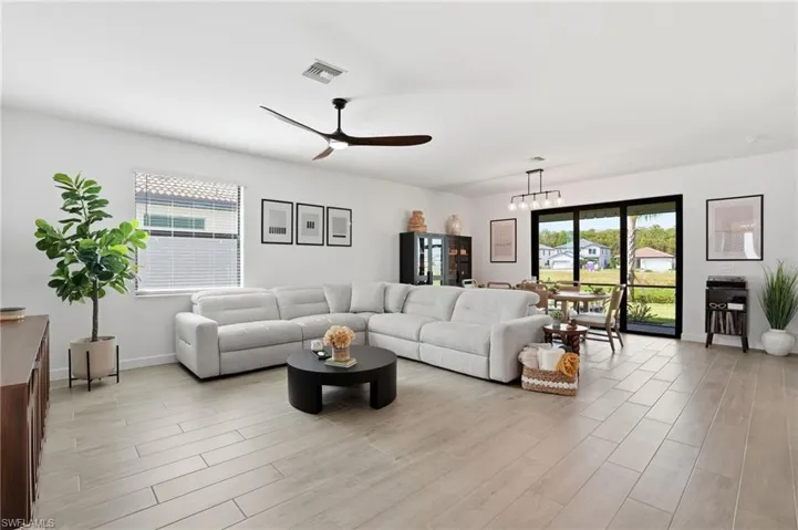 Living area featuring a ceiling fan, light wood finished floors, and healthy amount of natural light