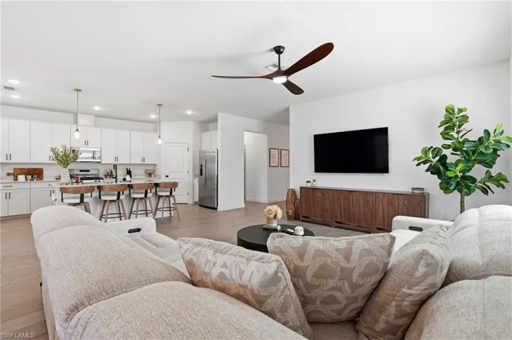 Living room featuring a ceiling fan, light wood-type flooring, and recessed lighting