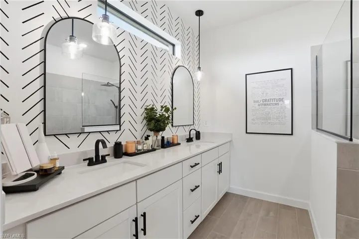 Full bathroom featuring double vanity, wood tiled floors, and walk in shower
