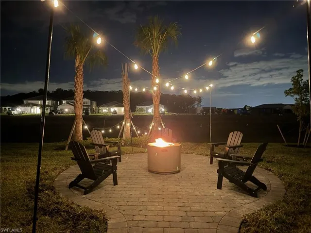 Patio at twilight featuring a patio area, a fire pit, and a lawn