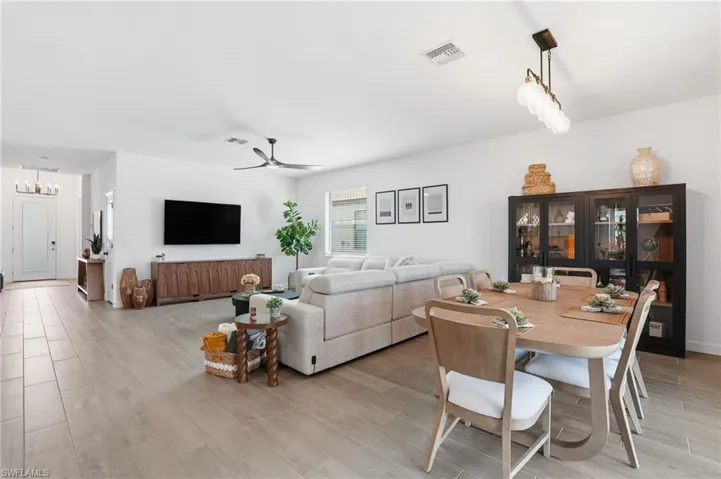 Dining space featuring wood tiled floors, a ceiling fan, and a chandelier