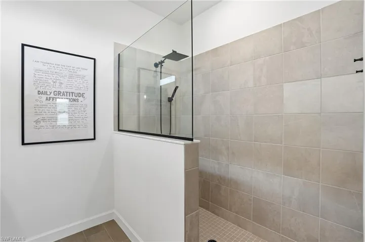 Bathroom with a walk in shower and baseboards
