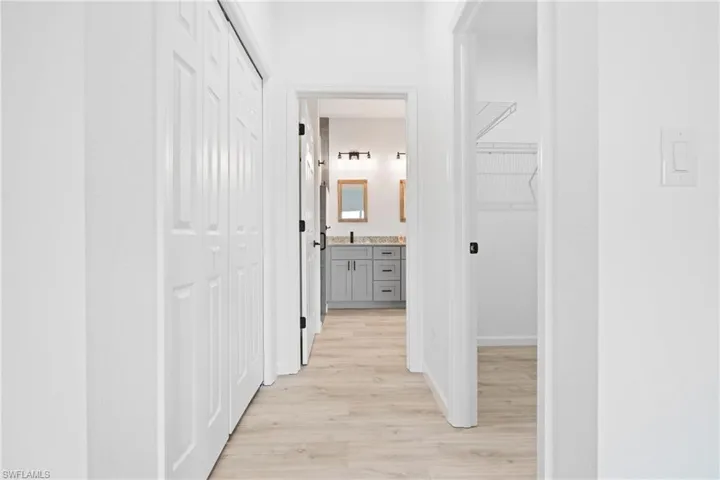 Hallway in primary bedroom with his & hers closet