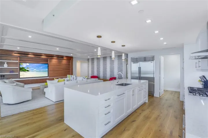 Kitchen featuring open floor plan, white cabinetry, appliances with stainless steel finishes, light wood-style floors, and recessed lighting