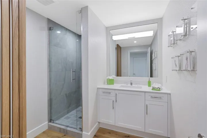 Full bathroom featuring a stall shower, wood finished floors, and vanity