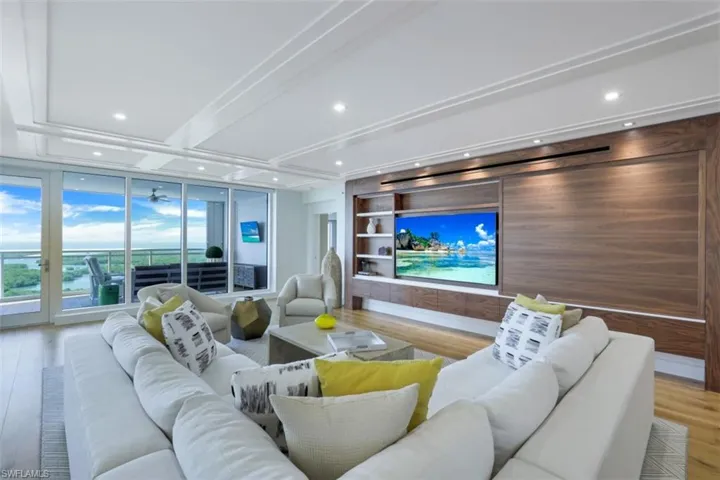 Living area with wood finished floors, recessed lighting, built in features, and floor to ceiling windows