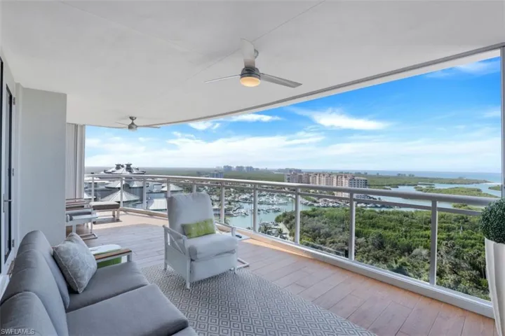 Balcony with ceiling fan, a water view, and a view of city