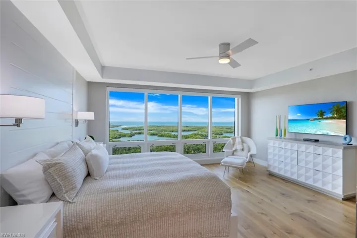 Bedroom with multiple windows, light wood finished floors, and a ceiling fan