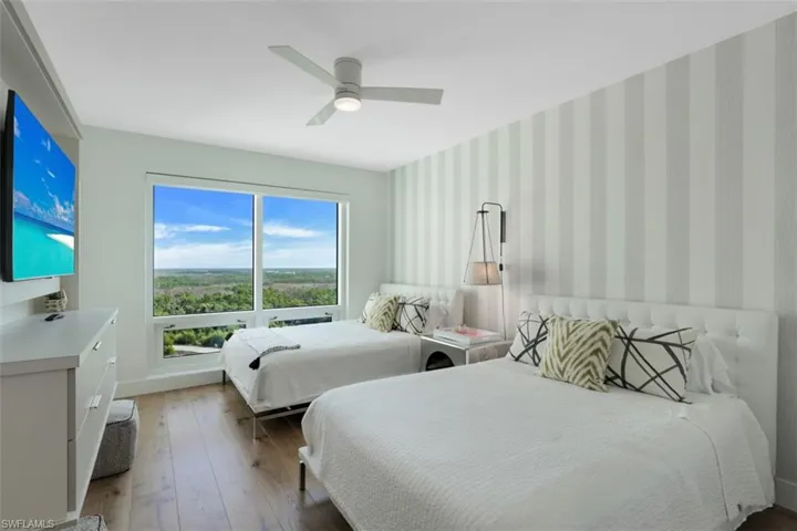 Bedroom featuring wallpapered walls, hardwood / wood-style floors, and ceiling fan