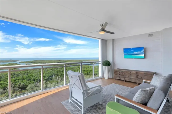 Balcony with a water view, ceiling fan, and an outdoor living space
