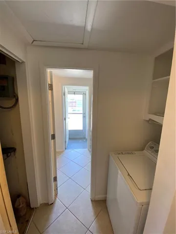 Laundry room featuring light tile floors and washer / clothes dryer