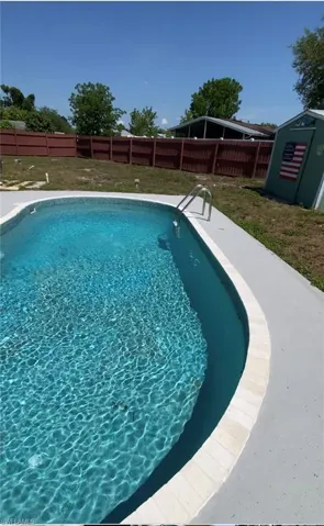 View of swimming pool featuring a yard