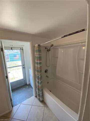 Bathroom featuring tile flooring and shower / tub combo