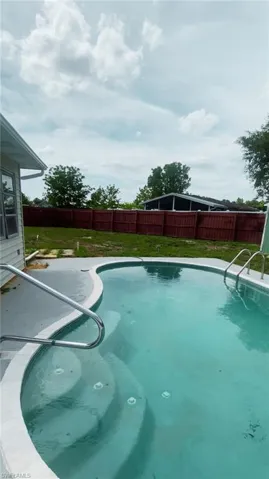 View of pool with a lawn