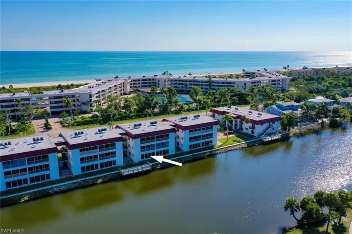 Drone / aerial view of apartment complex / building and a nearby body of water
