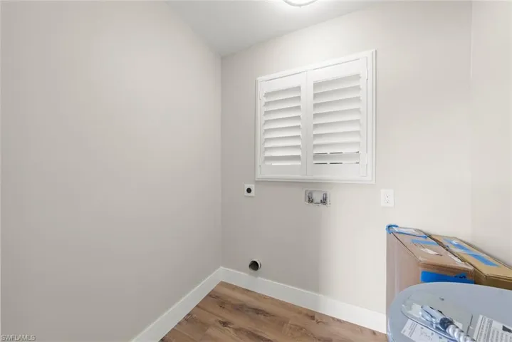 Laundry room featuring wood finished floors, electric dryer hookup, and hookup for a washing machine