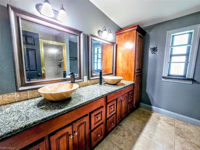 Bathroom with tile patterned floors, an enclosed shower, and vanity