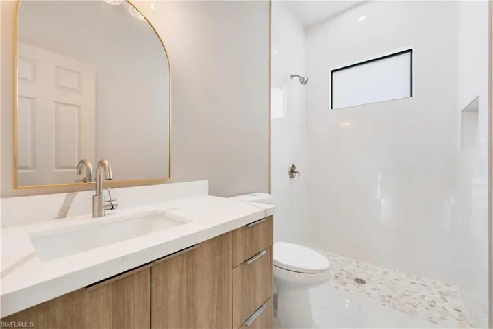 Full bath with vanity, a tile shower, and light tile patterned floors