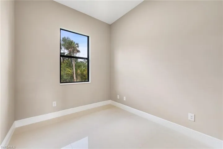 Empty room featuring baseboards and vaulted ceiling