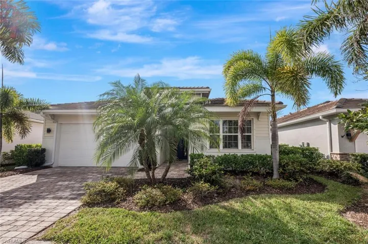 View of front of property with decorative driveway, stucco siding, a garage, and a tiled roof
