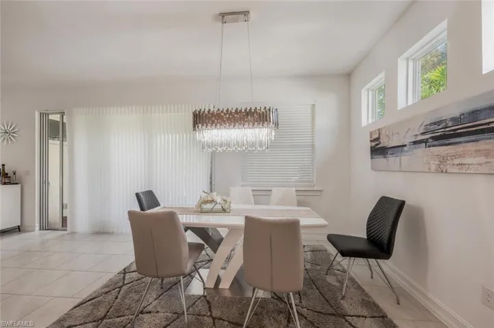 Dining space with hanging lights and light tile patterned floors