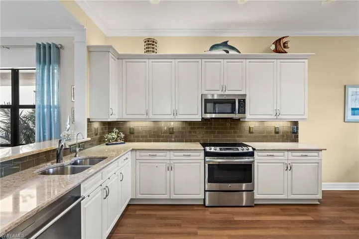 Kitchen view from foyer...crown molding, beautiful backsplash, light and bright!