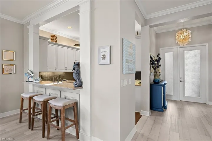 Foyer and bar seating for 3 captured in this shot. Easily pass food from kitchen to dining room! Note the custom millwork beyond  and to the right of the bar stools!