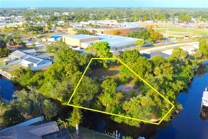 View of property location with property boundaries highlighted and a tree filled landscape