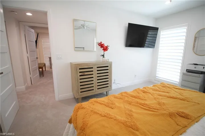 Bedroom with light colored carpet and recessed lighting