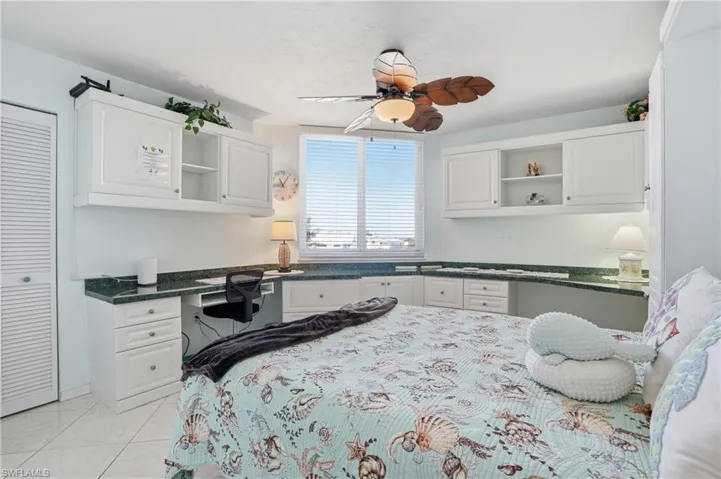 Bedroom featuring built in study area, a ceiling fan, and a closet - Virtually Edited Image