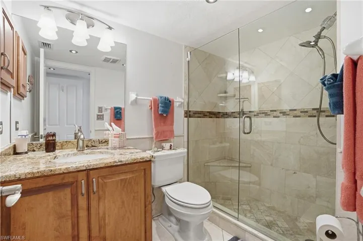 Bathroom with vanity, a shower stall, wainscoting, and recessed lighting - Virtually Edited Image
