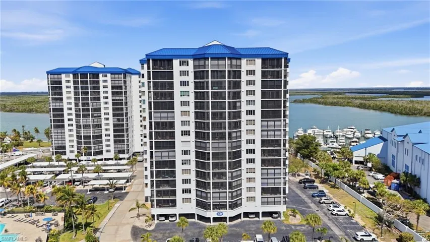 View of apartment building / complex featuring a water view - Virtually Edited Image