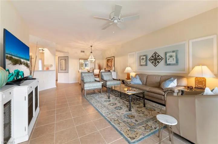 Living room with light tile patterned floors and ceiling fan