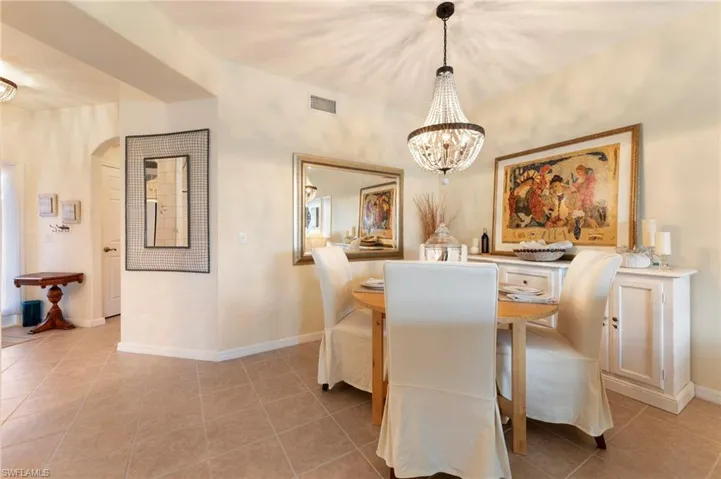 Dining room featuring a chandelier, light tile patterned flooring, and arched walkways