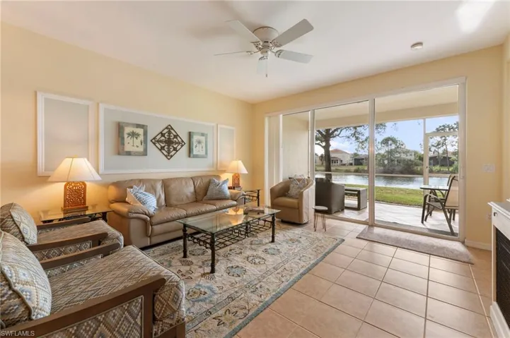 Living area featuring a water view, ceiling fan, and light tile patterned floors