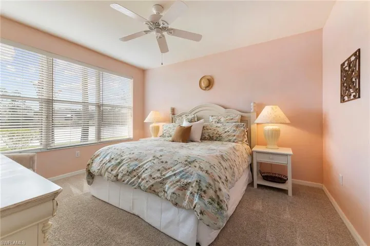 Carpeted bedroom with baseboards and a ceiling fan