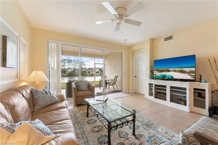 Living room featuring light tile patterned floors and a ceiling fan