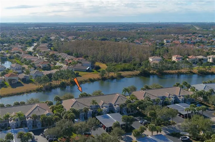 Aerial view of residential area featuring a nearby body of water