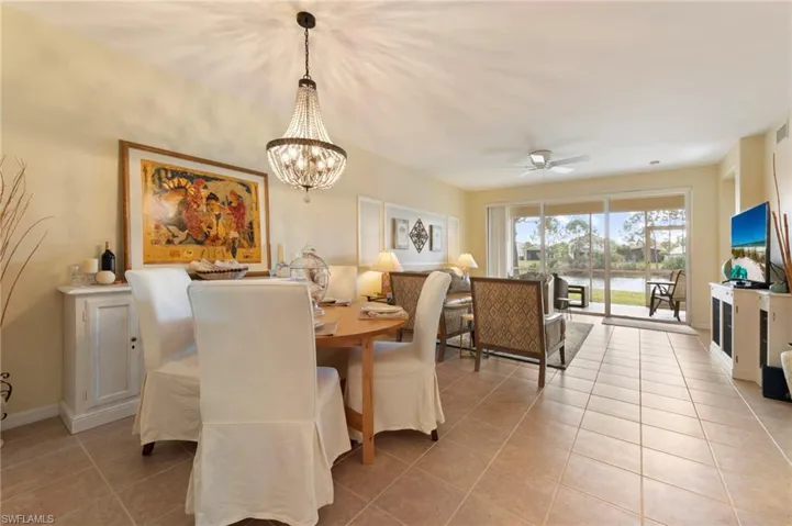Dining area with a chandelier, a ceiling fan, and light tile patterned floors