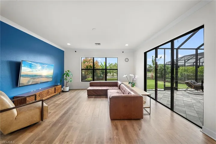 Spacious living area featuring wood-finish flooring and a distinctive blue accent wall