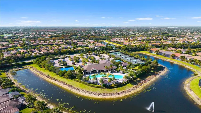 Expansive community grounds featuring a central clubhouse, two resort-style pools with surrounding lounge areas, multiple tennis courts, and basketball courts