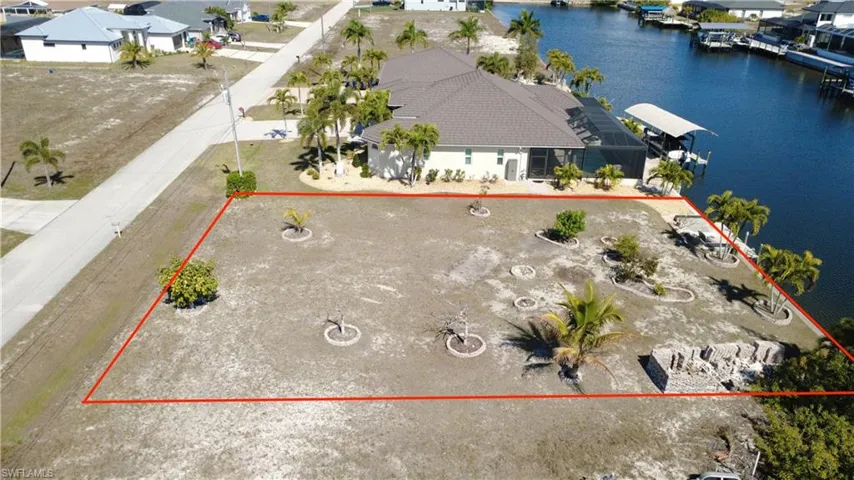 Aerial perspective of suburban area with a large body of water and property parcel outlined